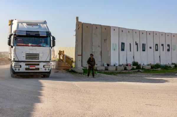 A truck carrying humanitarian aid moves at the Israeli side of the Kerem Shalom border crossing with the southern Gaza Strip on December 19, 2023, amid the o<em></em>ngoing co<em></em>nflict between Israel and the Palestinian militant group Hamas. (Photo by Menahem Kahana / AFP)